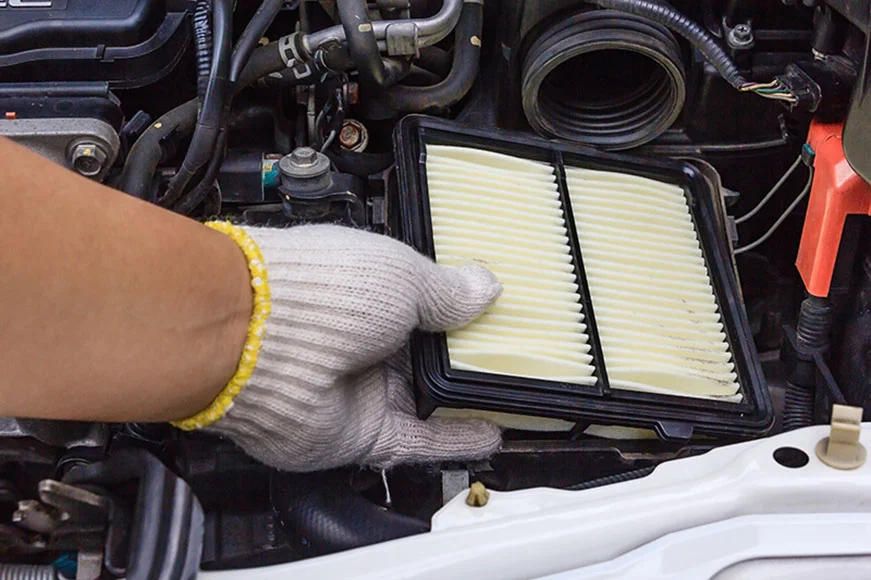 GMC technician replacing an air filter.